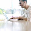 Man smiling while using laptop