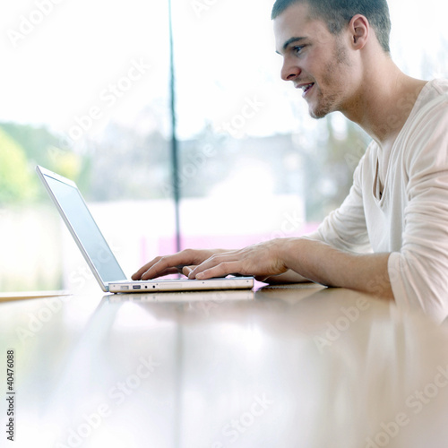 Photo: Man smiling while using laptop Man smiling while using laptop