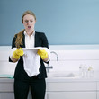Businesswoman with rubber gloves looking at baby clothing
