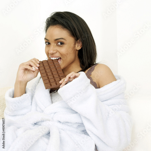 Photo: Woman in bathrobe enjoying a bar of chocolate Woman in bathrobe enjoying a bar of chocolate