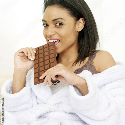 Photo: Woman in bathrobe enjoying a bar of chocolate Woman in bathrobe enjoying a bar of chocolate