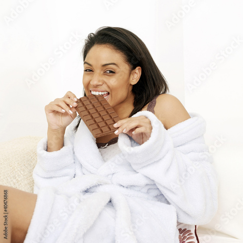 Photo: Woman in bathrobe enjoying a bar of chocolate Woman in bathrobe enjoying a bar of chocolate