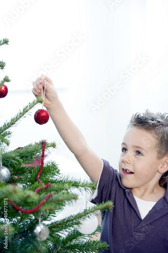 Foto: A boy decorating the Christmas tree A boy decorating the Christmas tree