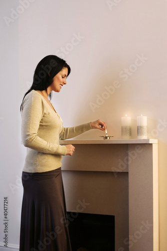Foto: Woman lighting up candles Woman lighting up candles