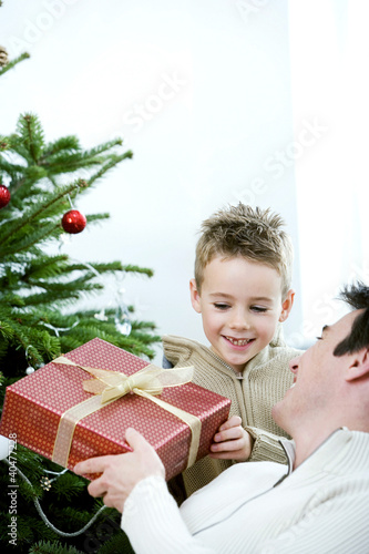 Photo: A father giving a Christmas present to his son A father giving a Christmas present to his son