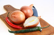 Onions, peppers and a knife on a cutting board Onions, peppers and a knife on a cutting board