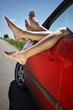 Legs hanging out of the car