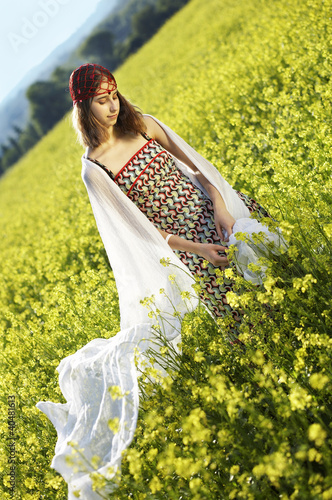 Photo: Dreaming Young Woman standing in the Rape Field Dreaming Young Woman standing in the Rape Field