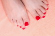 woman feet with red toenails on towel
