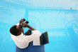 Businessman sitting on starting block using binoculars