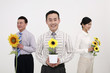 Business people holding sunflowers