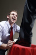 Businessman polishing another businessman's shoe