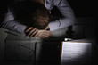 Distraught businessman with his head on the table, covering his face