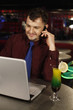 Man talking on the phone while using laptop