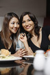 Women listening to a call together on the mobile phone
