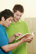 Two men reading a book