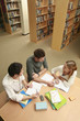 Two men and a woman having discussion in the library