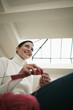 Woman sitting on couch knitting