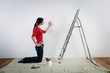 Woman checking a painted wall