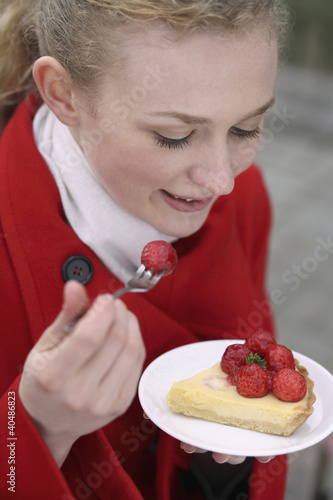 Photo: Woman enjoying strawberry tart Woman enjoying strawberry tart
