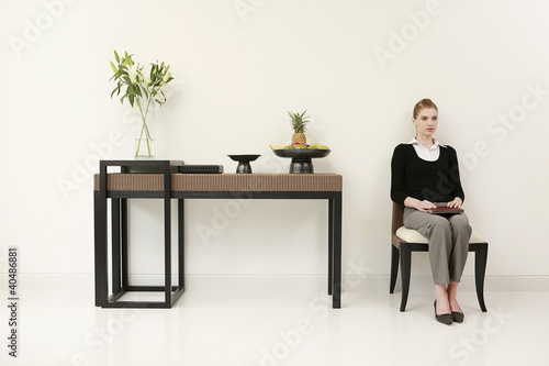 Foto: Woman in formal wear with book on her lap Woman in formal wear with book on her lap