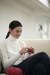 Woman sitting on couch knitting