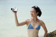 Woman in bikini using video camera