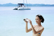 Woman in bikini using video camera