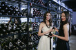 Women posing with a bottle of wine
