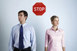 Foto: Businessman and businesswoman looking at different directions with a 'Stop' sign in between them Businessman and businesswoman looking at different directions with a 'Stop' sign in between them