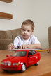Boy looking at toy car while drawing