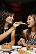 Woman feeding her friend garlic bread