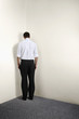 Businessman standing in corner of room