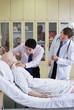 Doctors examining dummy patient on the bed