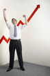 Businessman shaking fist in victory, arrow sign going up