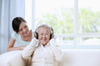 Photo: Senior woman listening to music on the headphones, woman looking at her Senior woman listening to music on the headphones, woman looking at her
