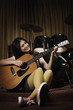 Young woman smiling while playing guitar