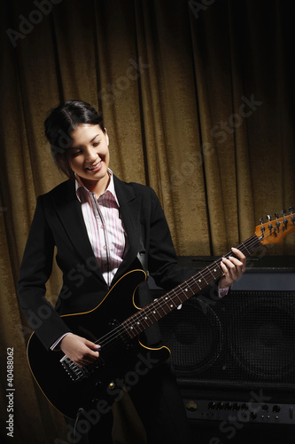 Photo: Young woman playing electric guitar Young woman playing electric guitar
