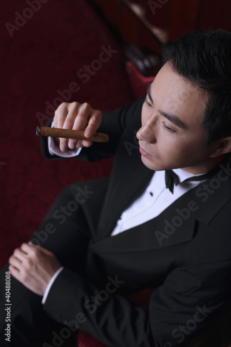Photo: Man in tuxedo holding a cigar Man in tuxedo holding a cigar