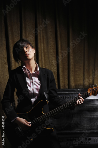 Photo: Young woman playing electric guitar Young woman playing electric guitar