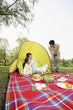 Girl and woman sitting in the tent, man looking at them