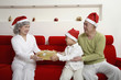 Foto: Boy giving senior woman present, senior man watching Boy giving senior woman present, senior man watching