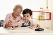 Foto: Senior woman teaching boy calligraphy Senior woman teaching boy calligraphy