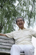 Foto: Senior man laughing while sitting on a swing Senior man laughing while sitting on a swing