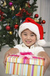 Foto: Boy with Christmas hat holding a box of gift Boy with Christmas hat holding a box of gift