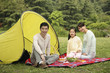 Girl and parents having picnic in the park