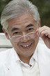 Foto: Senior man smiling while adjusting his spectacles Senior man smiling while adjusting his spectacles