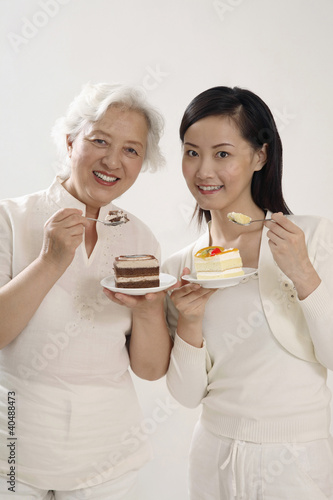 Photo: Senior woman and woman enjoying their cakes Senior woman and woman enjoying their cakes