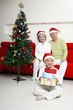 Foto: Boy holding a stack of presents, senior man and senior woman watching Boy holding a stack of presents, senior man and senior woman watching