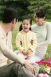 Girl and parents having picnic in the park